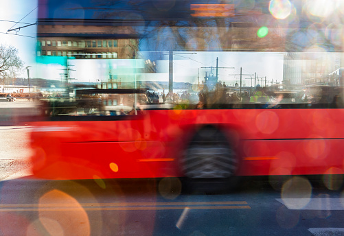 Backlit  blurred red bus with bokeh lights  in the street.  Aker Brygge, Oslo, Norway.