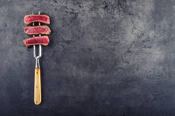 istock Slices of sirloin beef steak on meat fork 515888144