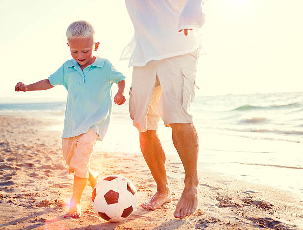 istock Father Son Playing Soccer Beach Summer Concept 515889432