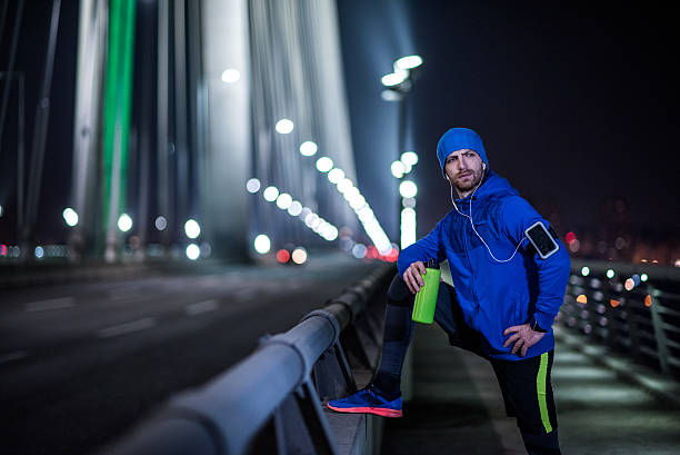 istock Man jogging through the city at night 515889716