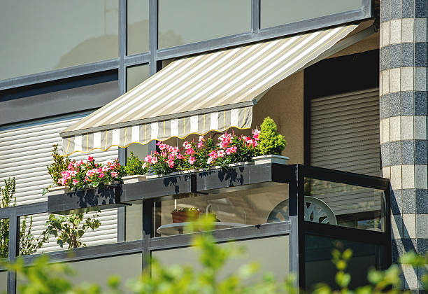 Balcony awning sun protection Balcony with awning opened and beautiful flowers - covered by sun-shield on a warm summer day awning stock pictures, royalty-free photos & images