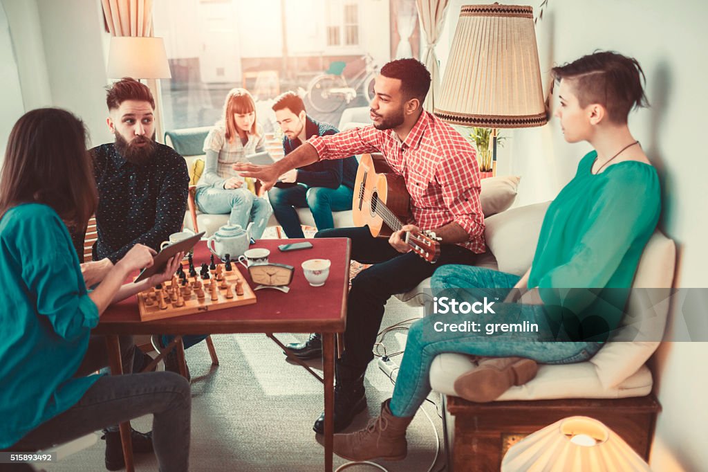 Group of young adults having fun in coffee shop Group of young adults having fun in coffee shop. Board Game Stock Photo