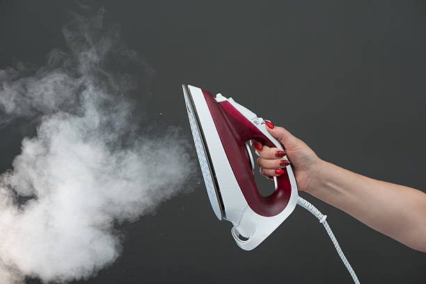 istock Woman holding an iron with steam 515907803