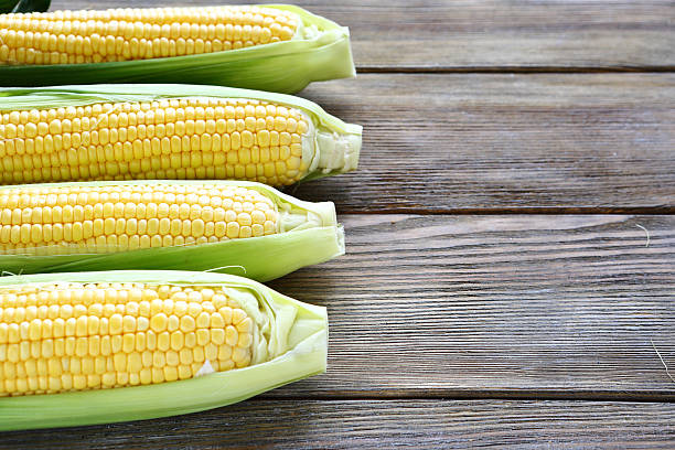 istock corn with leaves on a wooden background 515910653