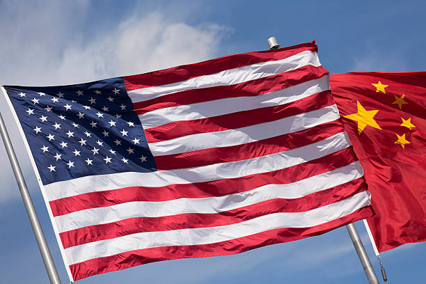 istock American Chinese windy day flags fly together on flagpole 515912302