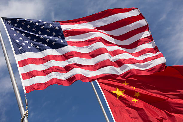 istock American Chinese windy day flags fly together on flagpole 515912454
