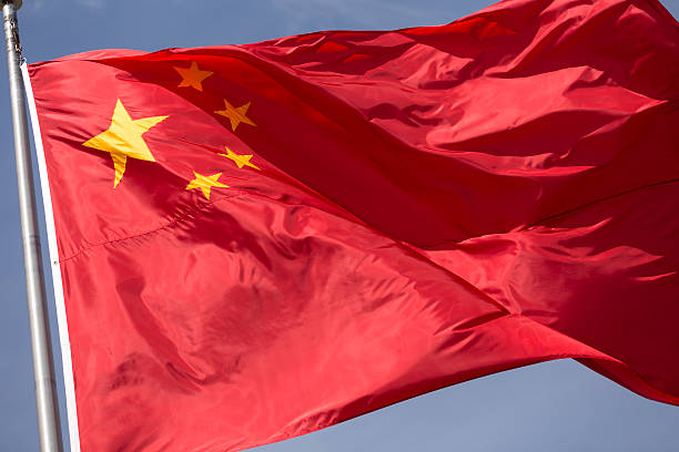 istock red yellow Chinese windy day flag flying on flagpole 515912564