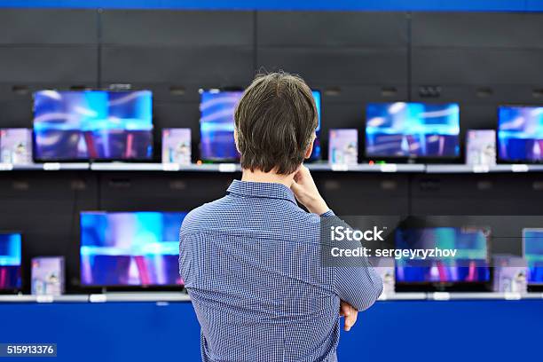 Uomo Che Guarda Tv Lcd In Negozio - Fotografie stock e altre immagini di Televisore - Televisore, Industria televisiva, Negozio