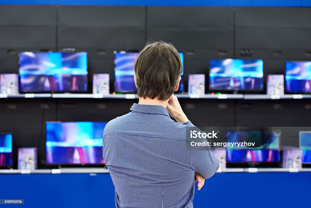 Man looks at LCD TVs in store Man looks at LCD TVs in supermarket Television Set Stock Photo