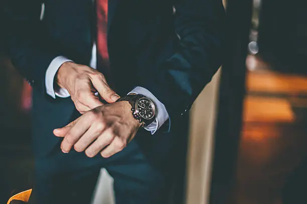Photo of Well Dressed Man putting his wrist watch