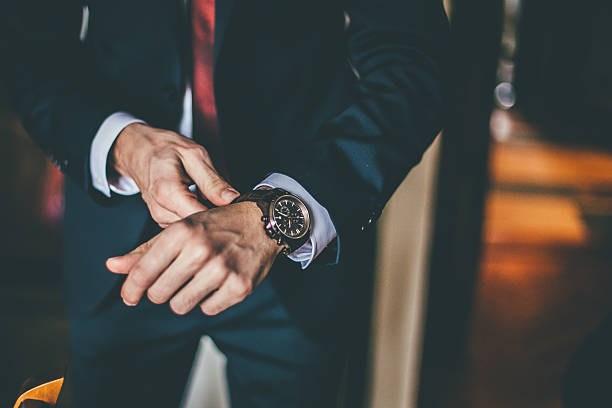 well dressed man putting his wrist watch - liten klocka bildbanksfoton och bilder