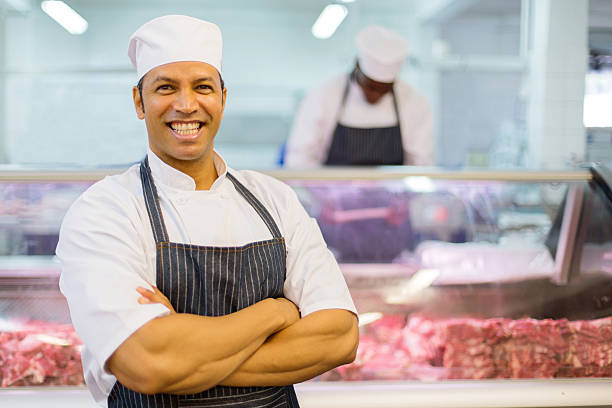 mid age male butcher with amrs folded