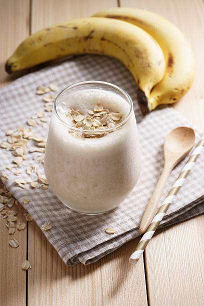 istock Banana smoothie on wooden background 515917684