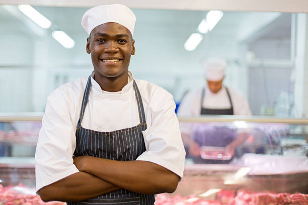 afro americano de carnicero brazos doblado - carnicería fotografías e imágenes de stock