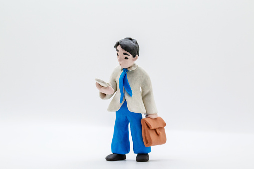 handmade clay figurine: office man reading mobile phone on the way