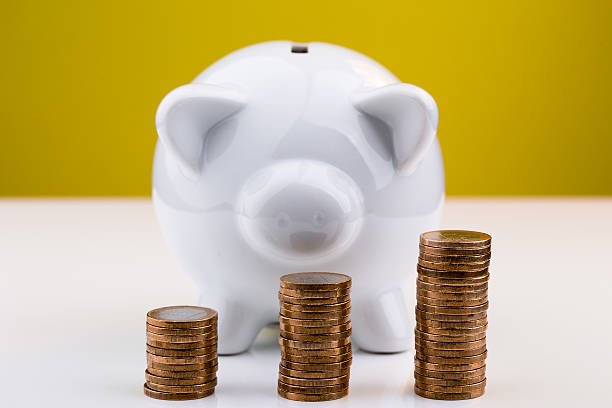 istock White piggy bank with stack of coins 515921344