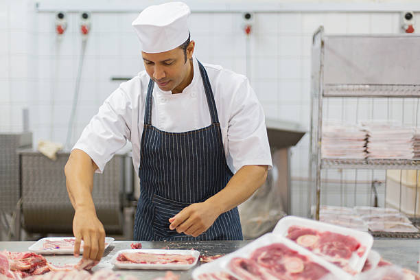 istock mid age butcher packing meat pieces 515921484