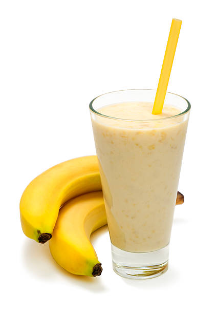 банановый молочный коктейль на белый фон - smoothie banana smoothie milk shake banana стоковые фото и изображения