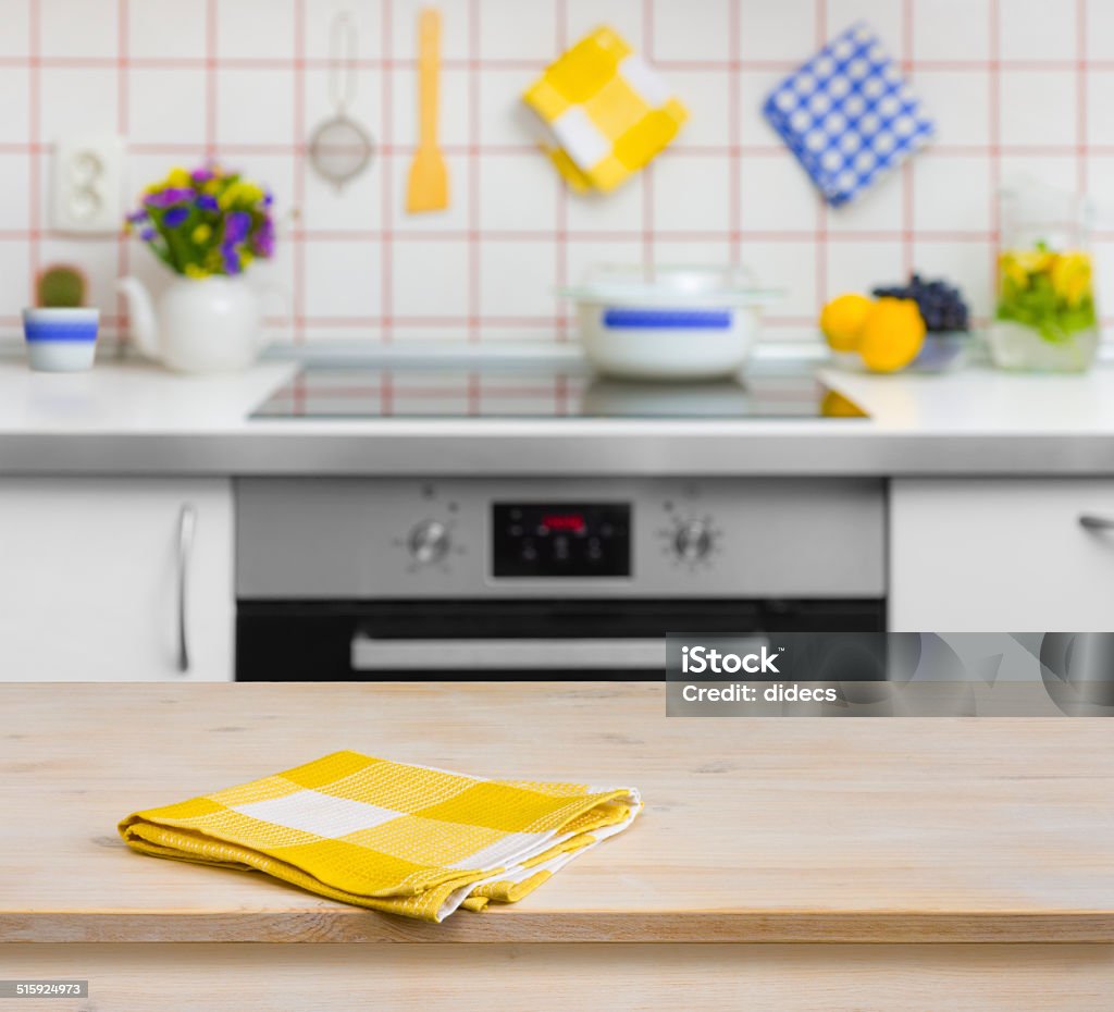 Wooden table with yellow napkin on kitchen background Towel Stock Photo
