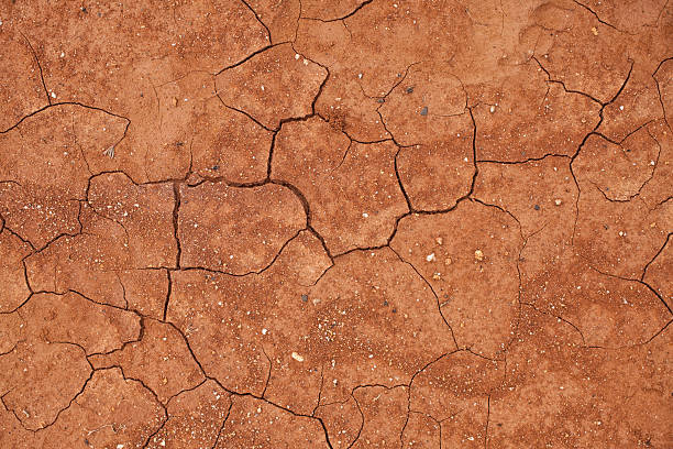 incrinato il terreno di argilla rossa - red earth foto e immagini stock