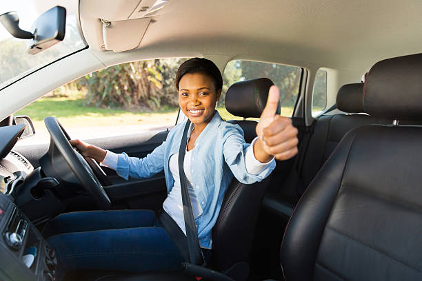 istock young african female driver giving thumb up 515927857
