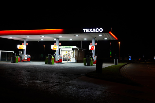 Cross Hands, UK - September 10, 2014: Forecourt of Texaco petrol station at night. The cashier is visible through teh window