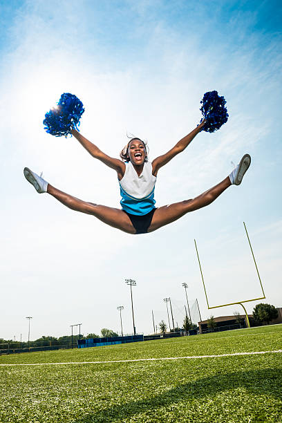 Cheerleader Split Leap Cheerleader doing a Split leap in American Football pitch. cheerleader photos stock pictures, royalty-free photos & images