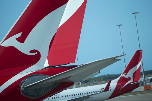 Brisbane, Australia - September 25, 2014: View through a window at part of two tails of Qantas planes parked on tarmac, the foreground tail is in focus , no people in photograph