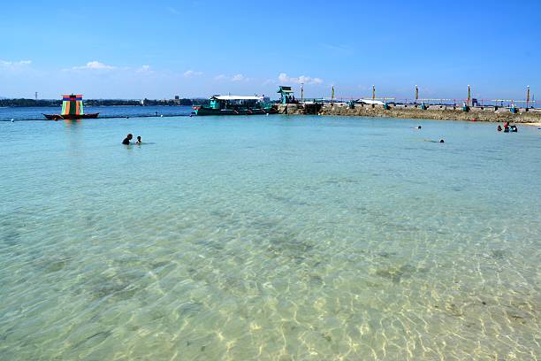 Samal island, Philippines - February 1, 2014: Paradise beach resort at Samal island. Local people bathing on the shallow and clear sea