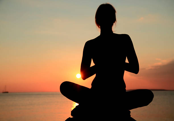 istock Young woman meditating by the sea 515961905