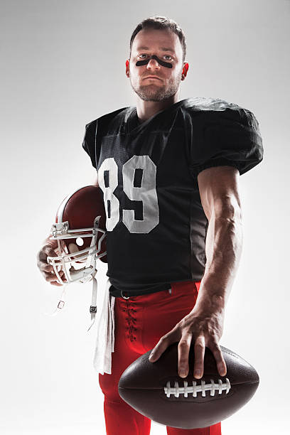 istock American football player posing with ball on white background 515964412