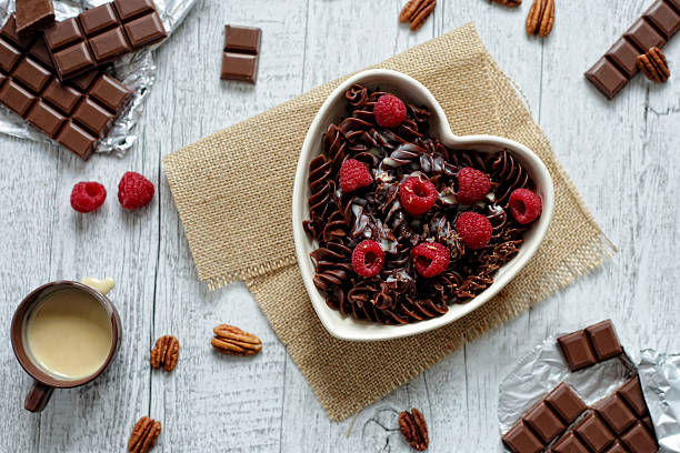 Chocolate pasta in a heart shaped bowl stock photo