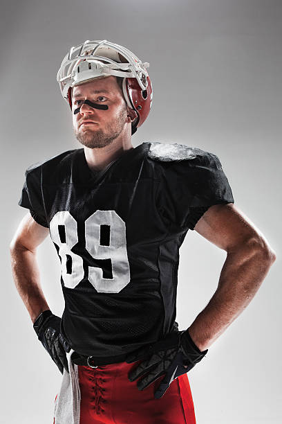 istock American football player posing with ball on white background 515965656