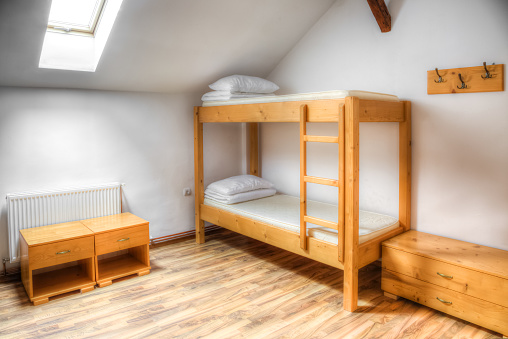 Clean hostel room with wooden bunk beds.