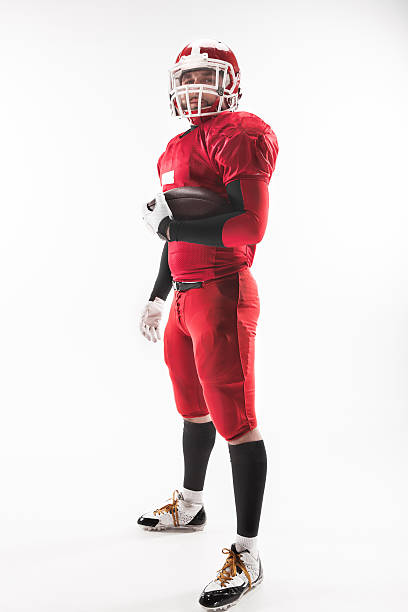 istock American football player posing with ball on white background 515965918