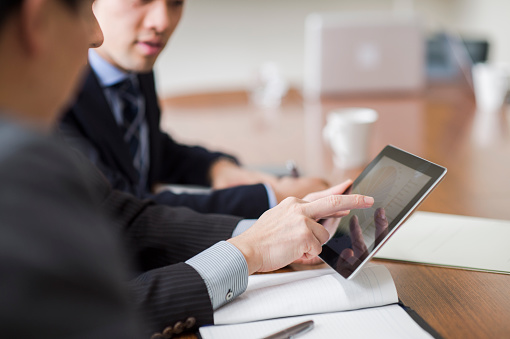 Male boss is in progress a meeting while using a digital tablet