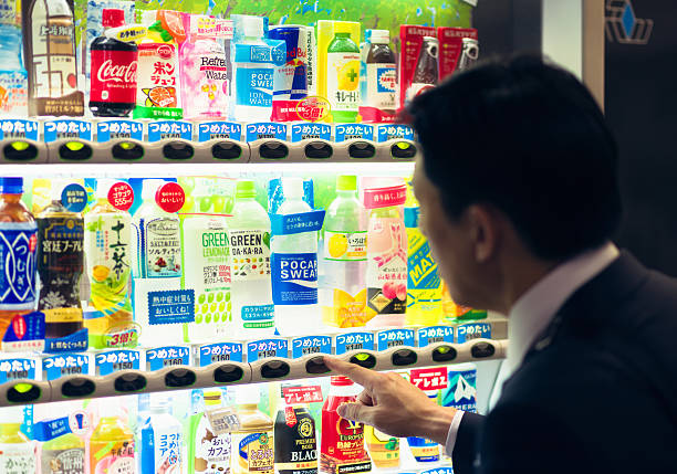 A man choosing from a wide range of drinks available at a Japanese vending machine in Tokyo.
