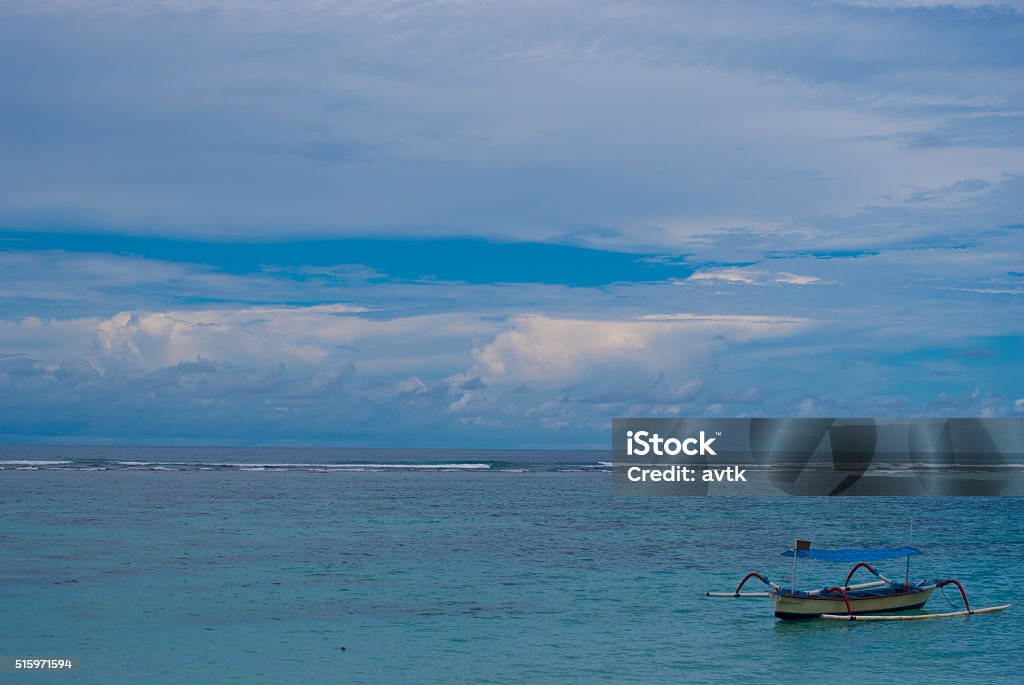 Lonely boat on the sea in Bali in cloudy weather. Asia Stock Photo