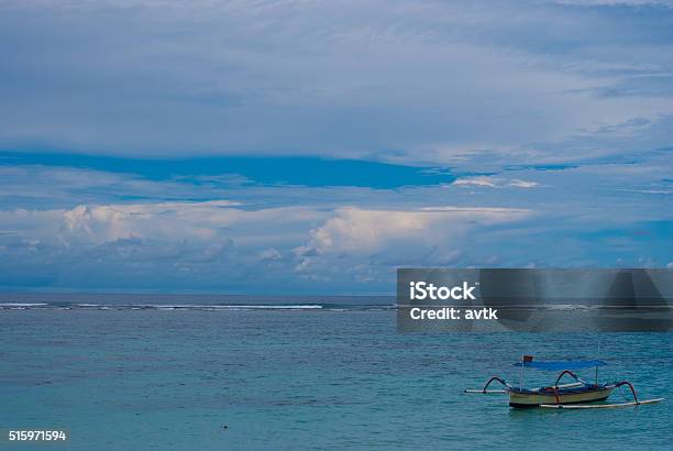 Lonely Boat On The Sea In Bali In Cloudy Weather Stock Photo - Download Image Now - Asia, Bali, Balinese Culture