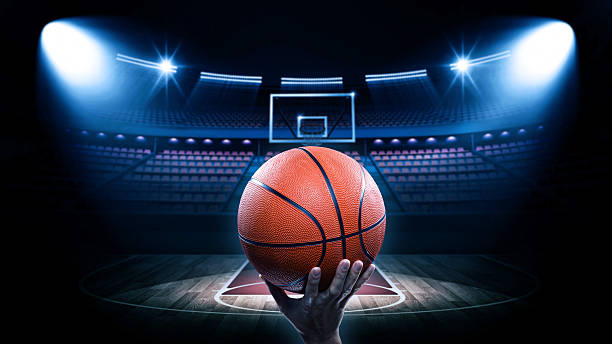 Basketball arena with player An imaginary stadium is modelled and rendered. basketball sport stock pictures, royalty-free photos & images
