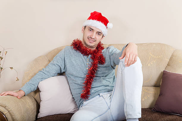 istock The young man ornate with Christmas decorations and red hat 515974060