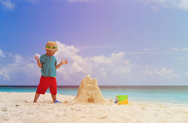 istock little boy building sand castle on beach 515974526
