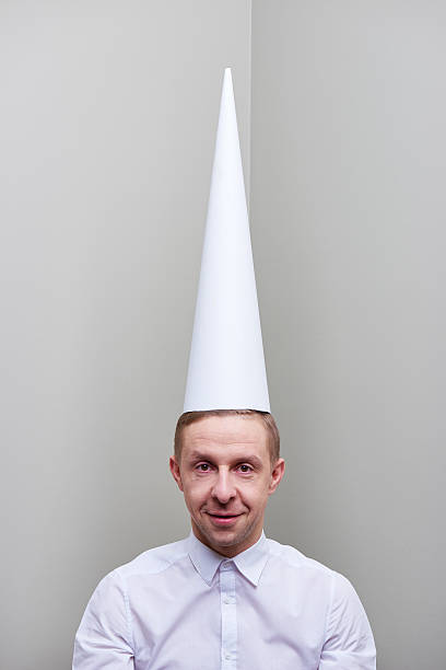 Dunce day Man in tall pointed cap looking at camera dunce cap stock pictures, royalty-free photos & images