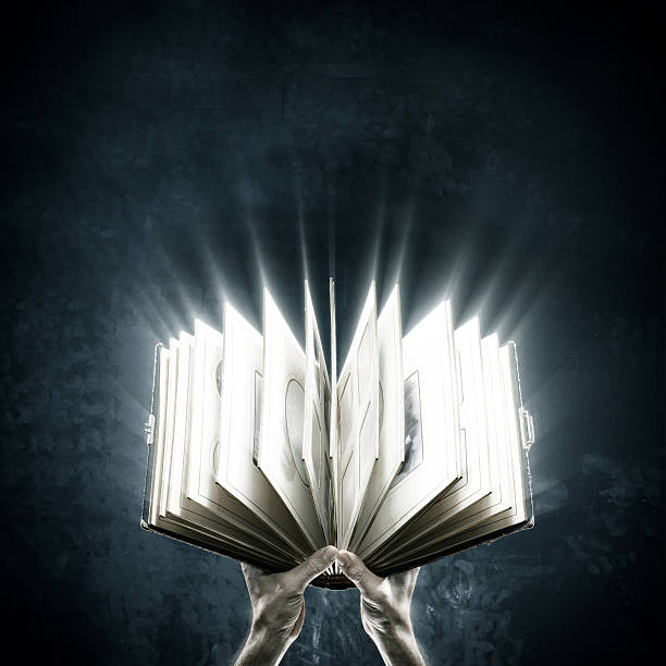 Opened magic book with magic lights Holding magic book wizard photos stock pictures, royalty-free photos & images