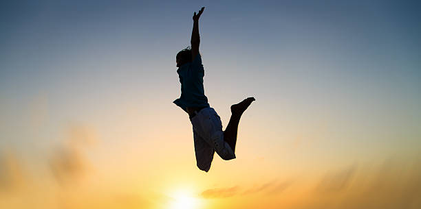 istock Silhouette of man jumping at sunset sky 515999500