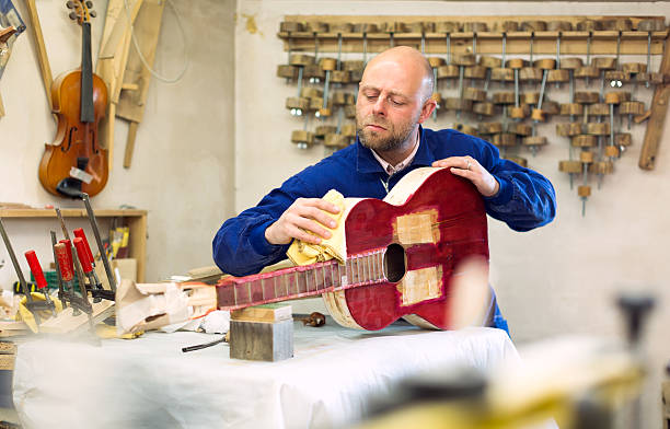 istock Carpenter preparing guitar for varnishing 515999666