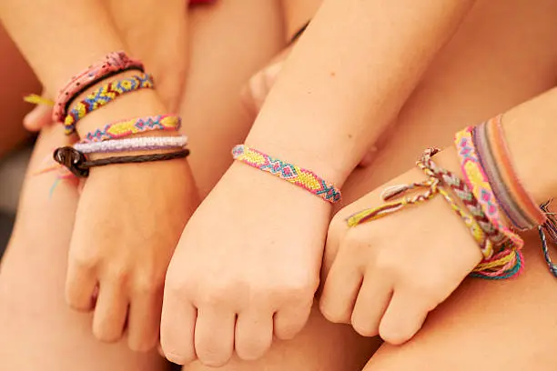 Cropped shot of teenage friends wearing friendship bracelets