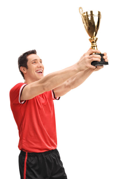 istock Joyful football player lifting a trophy 516005740