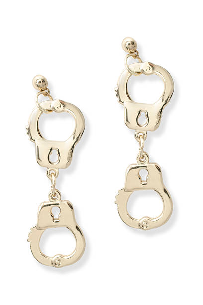 istock gold earrings handcuffs isolated on white 516006272