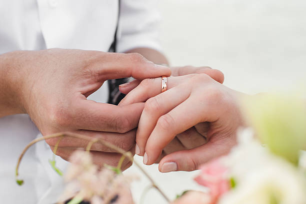 Groom and bride Groom wears the ring on the finger of the bride wedding ring stock pictures, royalty-free photos & images